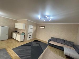 a living room with a couch and a kitchen at Kapshagay Lake in Kapchagay