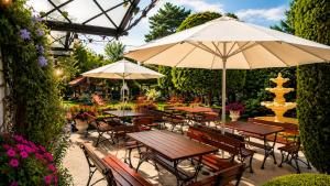 an outdoor patio with tables and umbrellas and a fountain at Pensjonat Angela in Łeba