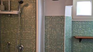 a bathroom with a shower with green tile at Terrazza Tosti in Formia +13 photos