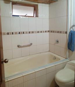 a bathroom with a bath tub and a toilet at Casa de campo san Andrés in Otavalo +20 photos