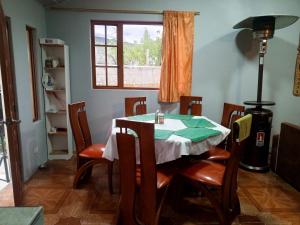a dining room with a table and chairs and a window at Casa de campo san Andrés in Otavalo