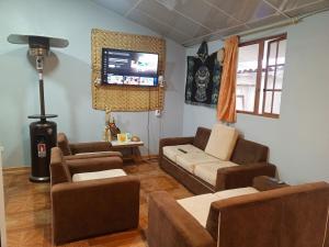 a living room with furniture and a flat screen tv at Casa de campo san Andrés in Otavalo