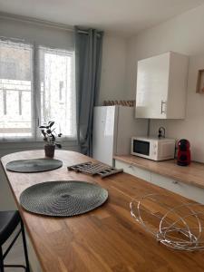 a kitchen with a wooden table with a microwave at Le Simplet in Perpignan +11 photos
