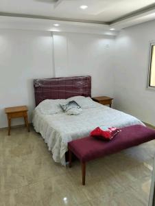 a bedroom with a large bed with a purple bench at Residence Dorra in Monastir