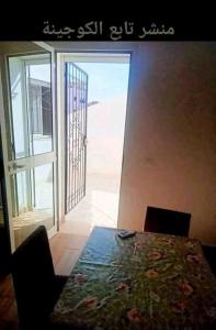 a dining room with a table and a sliding glass door at Residence Dorra in Monastir
