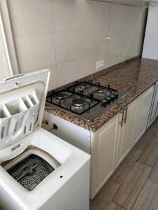 a stove top oven in a kitchen with a dishwasher at Residence Dorra in Monastir