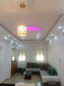 a living room with a couch and a pink light at Residence Dorra in Monastir