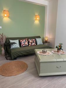 a living room with a green couch and a table at Le Simplet in Perpignan