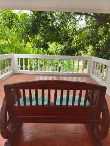 a wooden bench on a porch with a white fence at AUM VILLA Homestay in Pondicherry and Auroville in Puducherry Airpoert