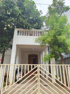 a white house with a white fence in front of it at AUM VILLA Homestay in Pondicherry and Auroville in Puducherry Airpoert +2 photos