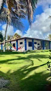 a building with palm trees in front of a yard at Casa Marina in Beberibe