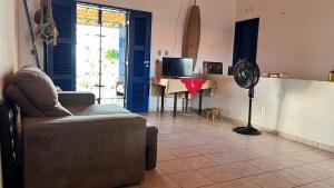 a living room with a couch and a fan at Casa Marina in Beberibe