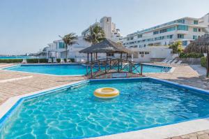 a swimming pool with a yellow object in the water at Beachfront Three-Story Coastal Penthouse, 3BR-3BA in Cancún