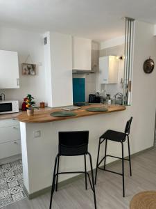 a kitchen with two bar stools and a counter at Le Simplet in Perpignan