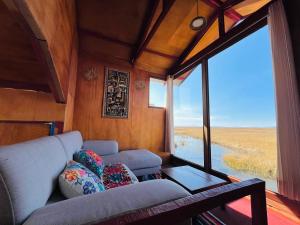a living room with a couch and a large window at Titikala in Puno +5 photos