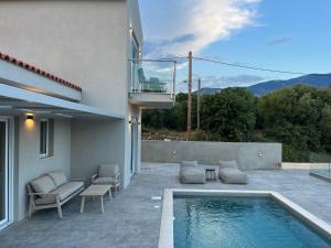 a backyard with a swimming pool and a house at Zefy's Scenic Oasis in Pesádha
