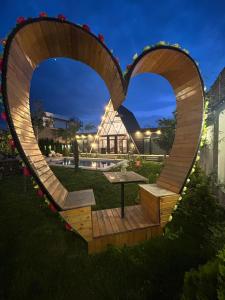 a heart shaped bench in a garden at night at Qafqaz Mountside Chalet in Gabala +60 photos