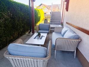 a patio with two wicker chairs and a table at Apartmani Srebrenik in Srebrenik