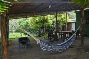 a porch with a hammock and a table and chairs at Beach-Front Bungalow in El Gigante