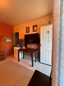 a room with a table and a tv and a door at Nonna Paulina in Timbó