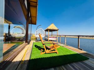 a deck with chairs and a gazebo on the water at Titikala in Puno