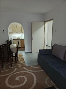a living room with a blue couch and a table at Apartman Kutak in Pirot +24 photos