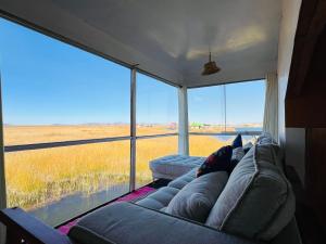 a couch in a room with a view of a field at Titikala in Puno