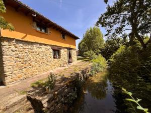 a building next to a river next to a building at Casa Menta in Pomar de Valdivia