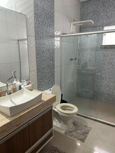 a bathroom with a shower and a toilet and a sink at Casa do Pedrão in Eunápolis