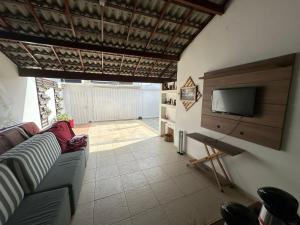 a living room with a couch and a flat screen tv at Casa do Pedrão in Eunápolis