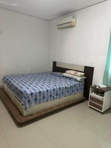 a bedroom with a bed and a night stand at Casa do Pedrão in Eunápolis