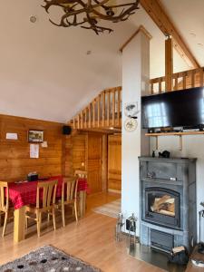 a living room with a fireplace and a table with chairs at Villa Wanda in Savonlinna