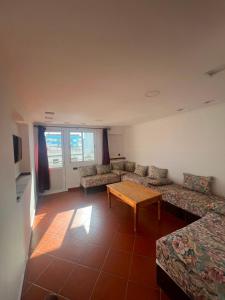 a living room with couches and a wooden table at Residence Jamal Only Family in Martil +8 photos