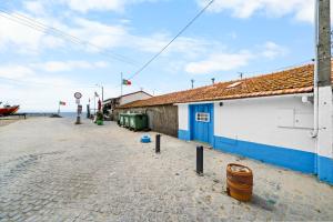a building on a beach next to the ocean at The Caravel Apúlia in Apúlia