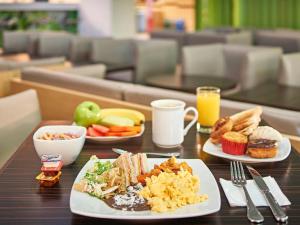 - une table avec deux assiettes de petit-déjeuner dans l'établissement Ace Hotel Ben Thanh, à Hô-Chi-Minh-Ville