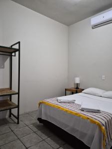 ein weißes Schlafzimmer mit einem Bett und einem Regal in der Unterkunft Bermejo Hostel LAP in La Paz + 31 Fotos