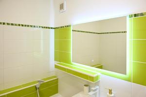 a green and white bathroom with a sink and a mirror at Sowa Rigpa apartmán in Gerlachov +18 photos