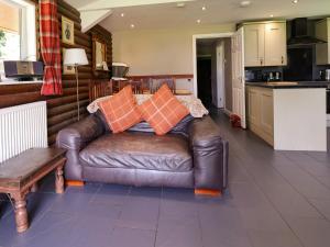 a leather couch with pillows on it in a kitchen at The Roe in St Asaph