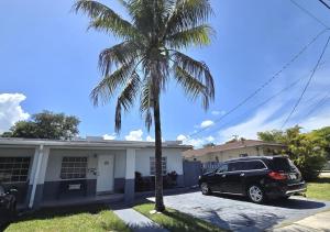 a car parked in front of a house with a palm tree at Miami Blue Oasis l 2BR with free parking in Miami