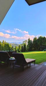 Eine Terrasse mit Stühlen, einem Tisch und Blick auf ein Feld in der Unterkunft Hajlanderka in Bustryk