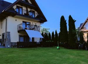 Ein Haus mit einem großen Garten mit Stühlen und Bäumen in der Unterkunft Hajlanderka in Bustryk + 76 Fotos