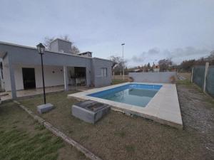 a swimming pool in a yard next to a house at Lusanyun3 in Villa Parque Siquiman +2 photos