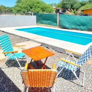 a table and chairs next to a swimming pool at Lusanyun3 in Villa Parque Siquiman