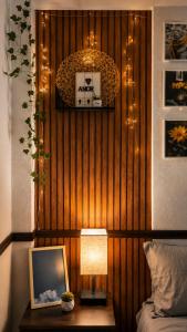 ein Schlafzimmer mit einer Holzwand und einem Tisch mit Lampe in der Unterkunft Casa Aoi Ideal para empresas y grupos de trabajo in Pachuca de Soto