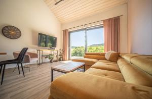 a living room with a couch and a large window at RosoChata313 Domek w górach z Sauną,Jacuzzi,Basenem "Panieński" ruska Bania na wyłączność in Mogilno