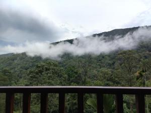 a balcony with a view of a mountain with clouds at Wishparing fall villa laxapane in Kiriwan Eliya