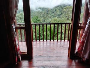 an open door to a balcony with a view of a mountain at Wishparing fall villa laxapane in Kiriwan Eliya