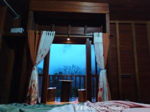 a bedroom with a view of a bed and a window at Wishparing fall villa laxapane in Kiriwan Eliya