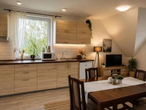 a kitchen with a dining table and a microwave at Lesný Dvor Retreat in Spišské Bystré