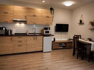 a kitchen with wooden cabinets and a white refrigerator at Lesný Dvor Retreat in Spišské Bystré +11 photos